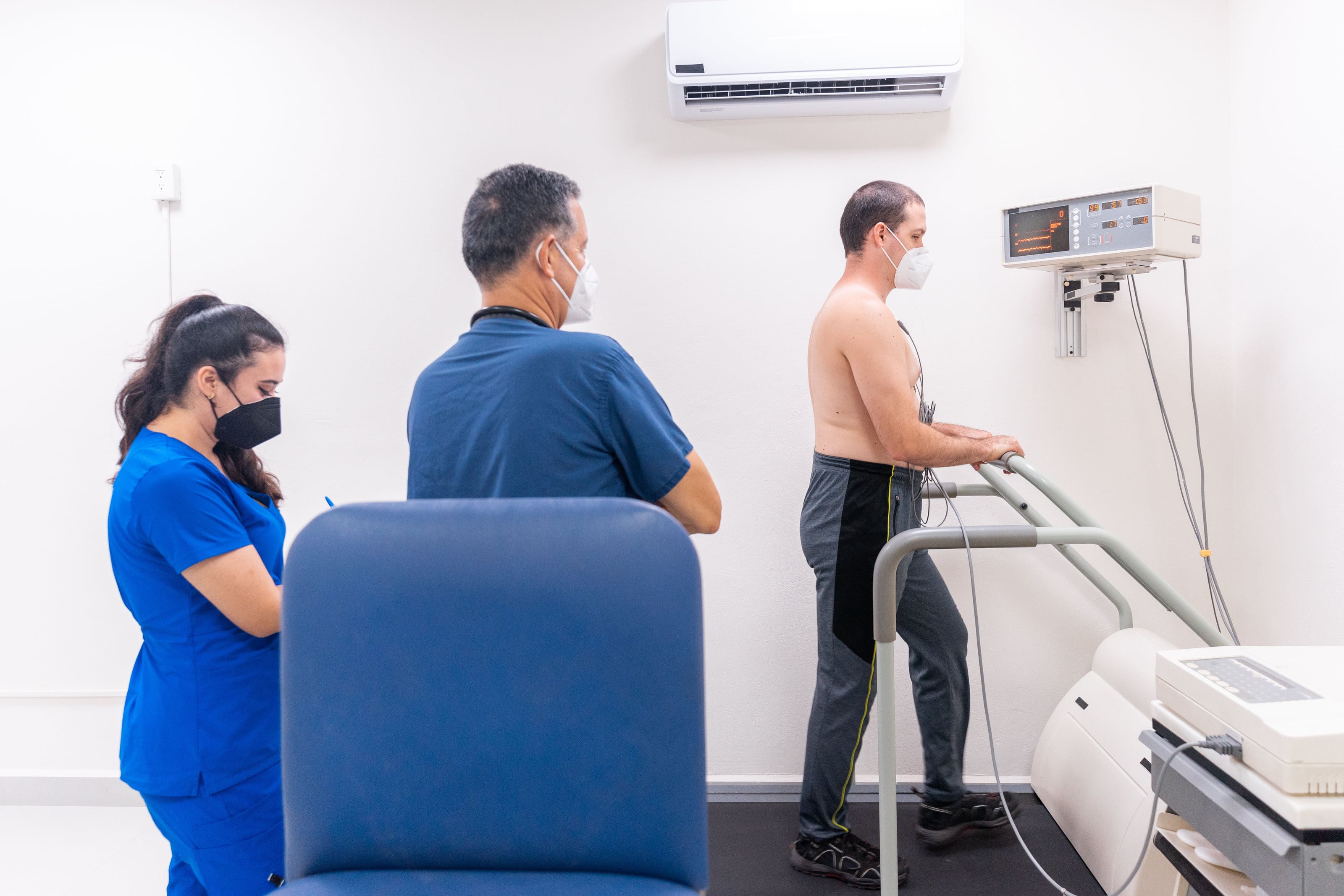 Paciente en prueba de esfuerzo sobre banda caminadora, acompañado por el equipo médico